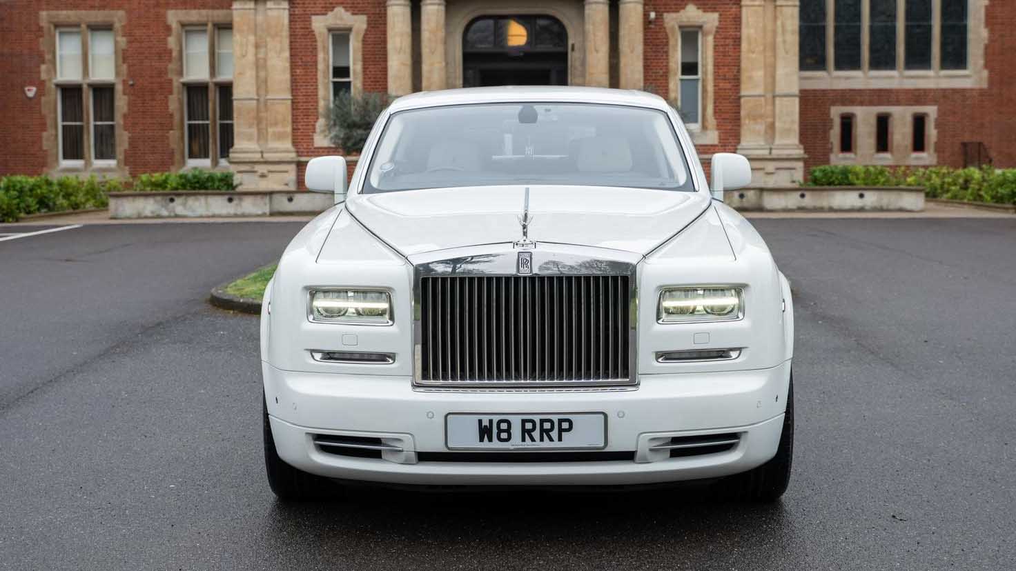 Front view of white Rolls-Royce Phantom Series II EWB with signature chrome grille and Spirit of Ecstasy.