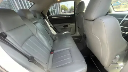Rear grey leather seats inside white Chrysler 300C wedding car, viewed through tinted rear windows.