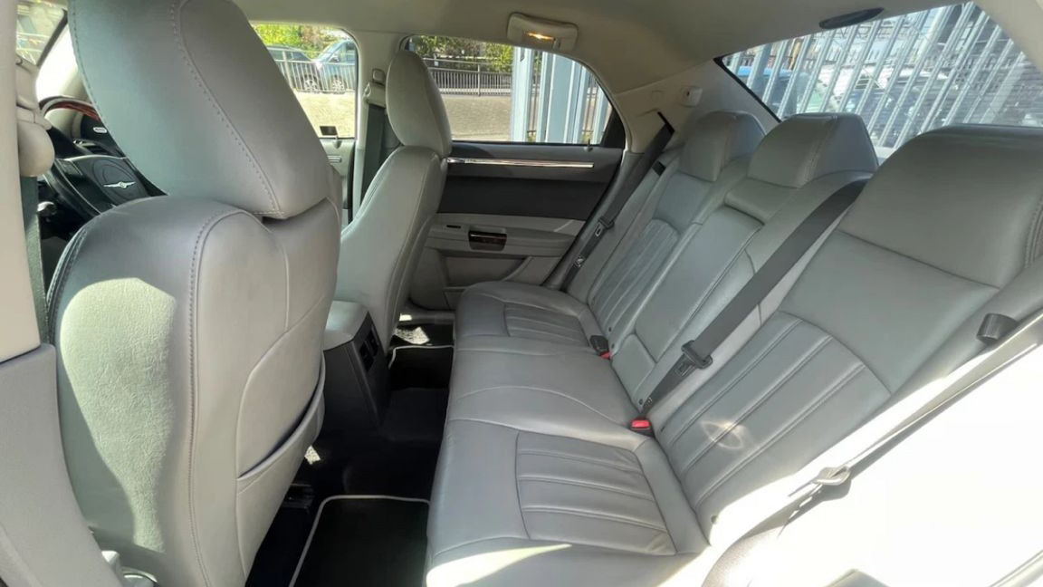 Rear leather seats inside modern Chrysler 300C saloon wedding car, showing grey upholstery and legroom.