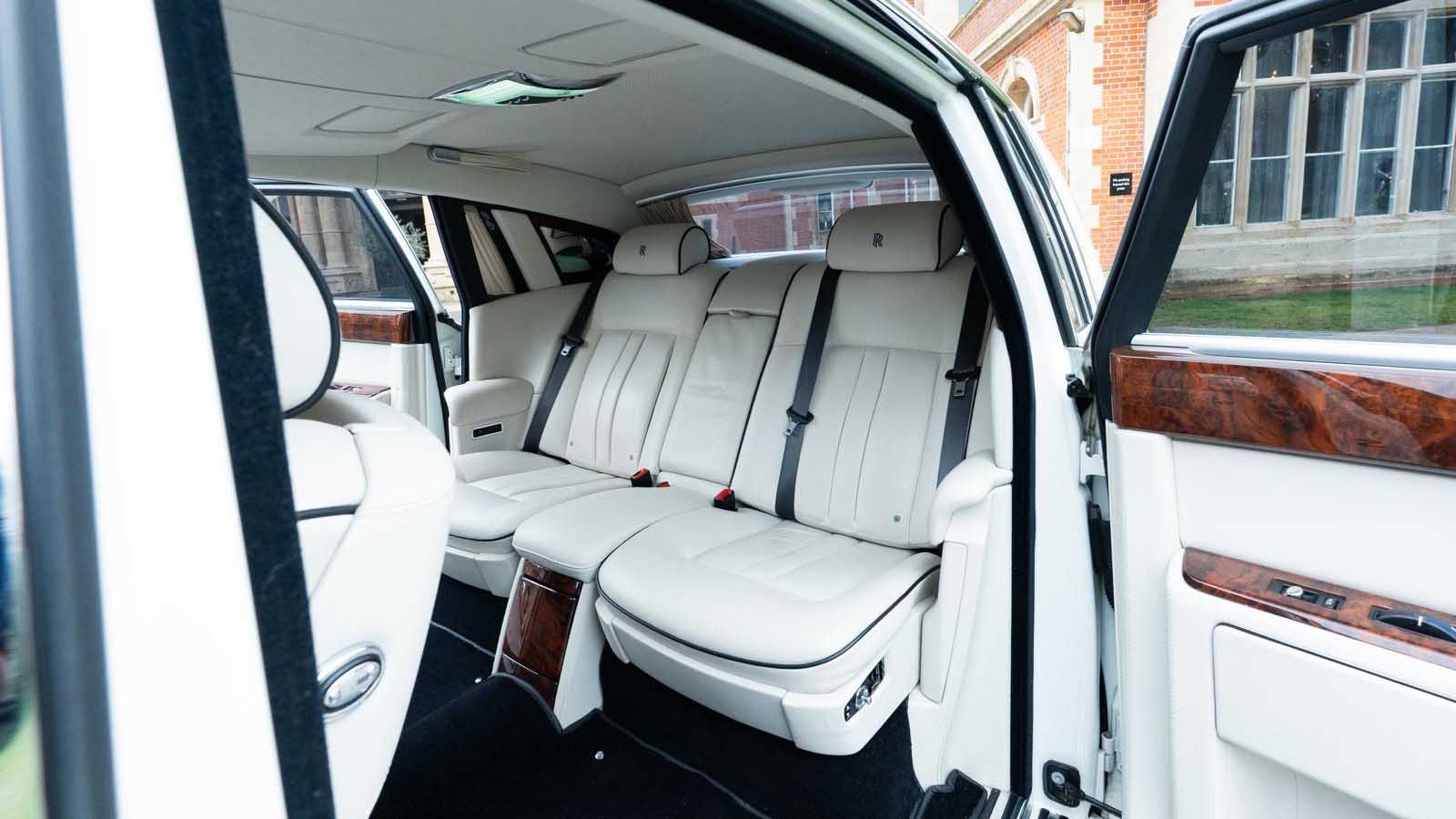 Spacious rear cabin inside Rolls-Royce Phantom Series II EWB with luxury white leather seating.