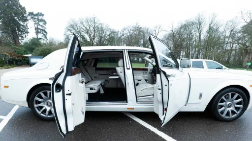 White Rolls-Royce Phantom Series II EWB with rear coach doors open outside wedding venue.