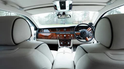 View from rear passenger seat inside Rolls-Royce Phantom Series II EWB with luxury wood dashboard.