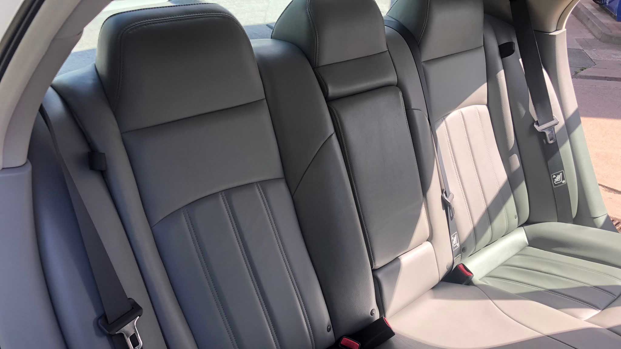Grey leather rear seats inside Chrysler 300C wedding car, showing seatbelts and centre seat.