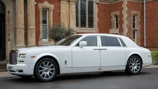 White Rolls-Royce Phantom Series II EWB parked outside elegant London venue.