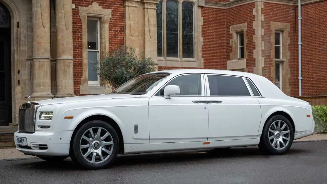 White Rolls-Royce Phantom Series II EWB parked outside elegant London venue.