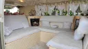 Rear lounge seating area inside ivory and sage green Volkswagen Split Screen wedding campervan.