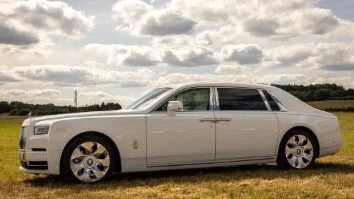 Left side view of White Rolls-Royce Phantom 8 with chrome wheels