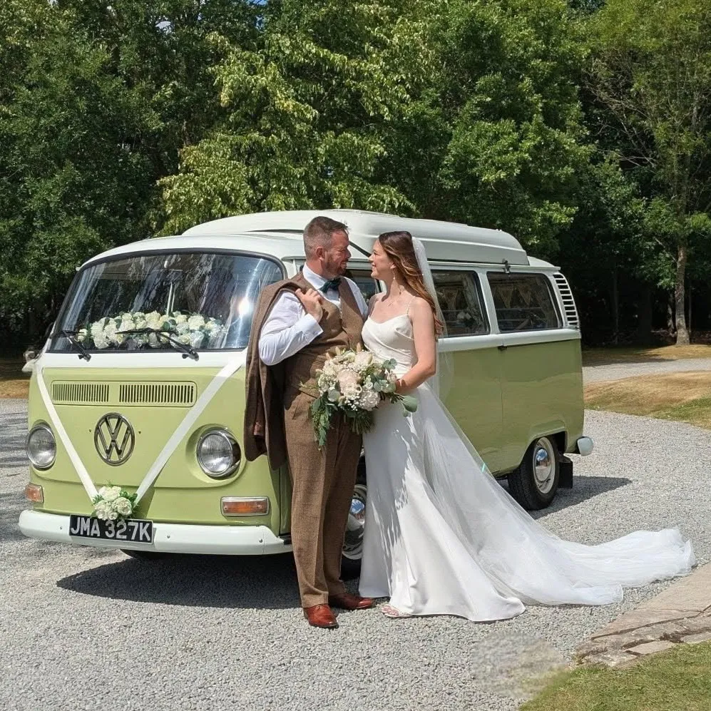 Bride and groom standing beside a green and cream VW campervan wedding car at Belfry Hotel in Sutton Coldfield.
