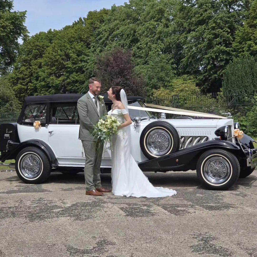 Bride and groom with a vintage Beauford wedding car in the West Midlands countryside