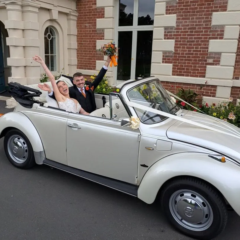 Bride and groom celebrating in a white VW Beetle convertible wedding car at Lightwoods Park in Bearwood.