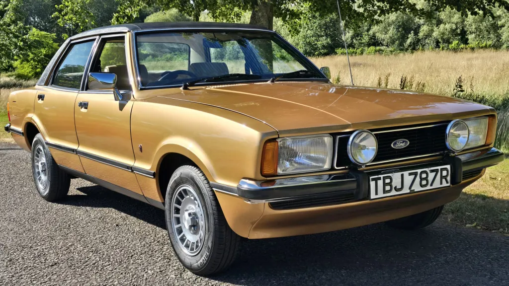 1977 Ford Cortina Mk4 Ghia in gold parked in countryside setting for classic wedding car hire.