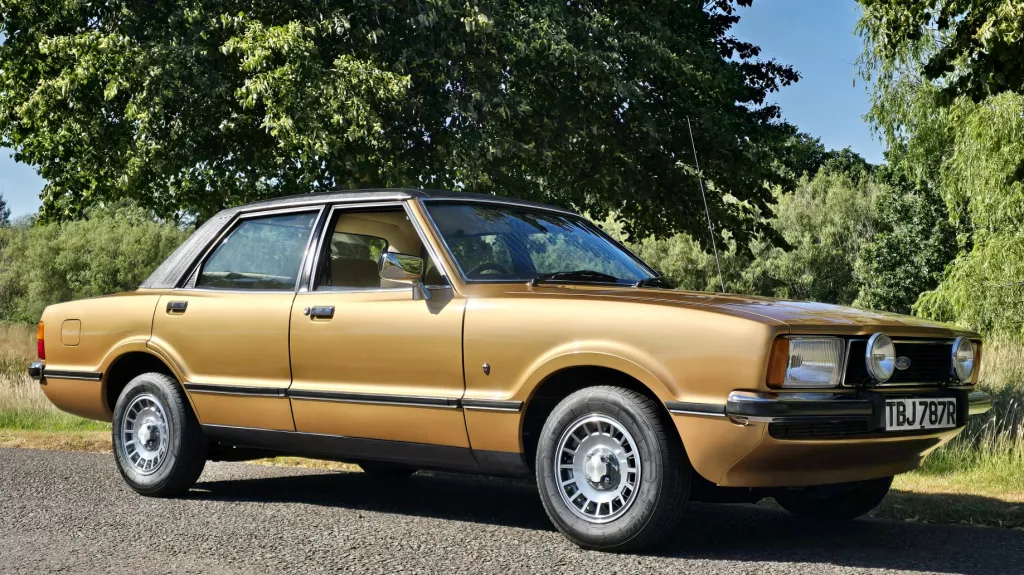 Front side view of gold 1977 Ford Cortina Mk4 Ghia with chrome trim and alloy wheels.
