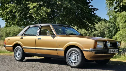 Front side view of gold 1977 Ford Cortina Mk4 Ghia with chrome trim and alloy wheels.