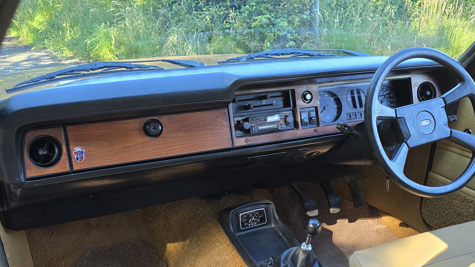 Classic wooden dashboard and steering wheel inside 1977 Ford Cortina Mk4 Ghia.