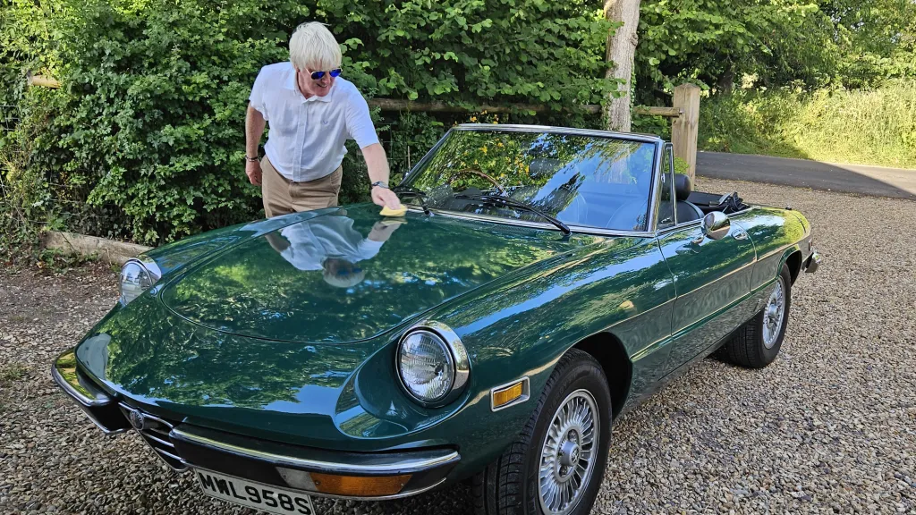 1978 Alfa Romeo Spider Veloce 2000 convertible in green parked outdoors for wedding hire in Wiltshire.