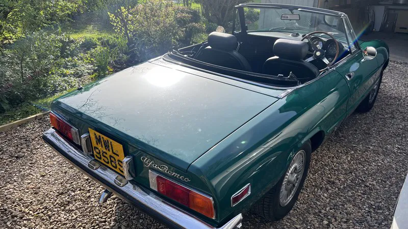 Rear view of green Alfa Romeo Spider Veloce 2000 with roof folded down and classic convertible styling.