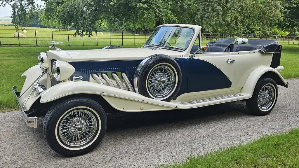 Side profile of blue and ivory Beauford convertible with roof folded down.