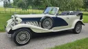 Side profile of blue and ivory Beauford convertible with roof folded down.