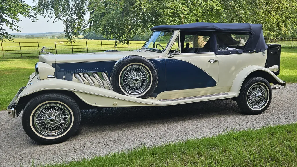 Blue and ivory Beauford convertible with navy blue soft top roof in the closed position.