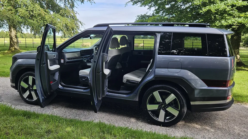 Hyundai Santa Fe Ultimate HEV with passenger doors open showing spacious seven seat interior.