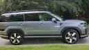 Full right side profile of blue Hyundai Santa Fe Ultimate HEV seven seater SUV parked outdoors.