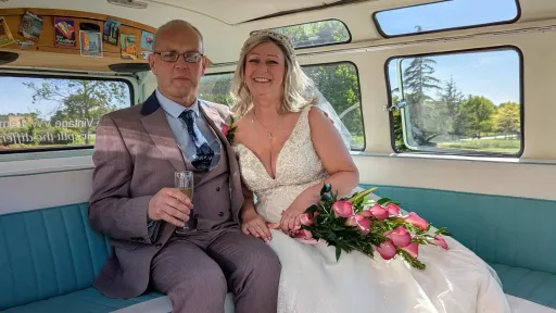 Bride and groom seated inside cream and green Volkswagen Split Screen campervan with vintage interior.