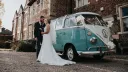 Blue and white 1964 Volkswagen Split Screen Samba campervan parked outside historic wedding venue in North Wales.