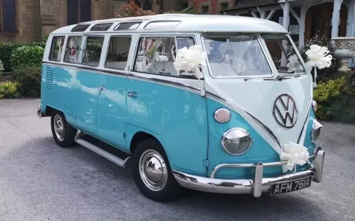 Front three quarter view of blue and white Volkswagen Split Screen Samba campervan decorated for a wedding in Denbigshire.