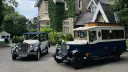 Navy blue and Old English White Asquith vintage wedding bus parked beside matching vintage wedding car outside Liverpool wedding venue.