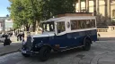 Navy blue and Old English White Asquith vintage wedding bus parked outside historic Liverpool buildings.