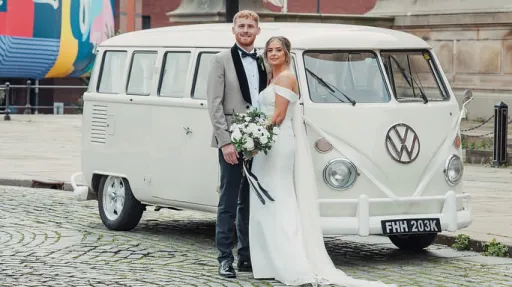 Bride and groom standing beside cream 1972 Volkswagen Split Screen campervan in Liverpool.