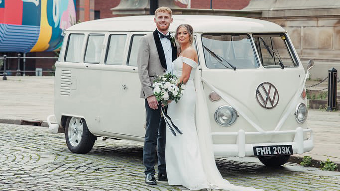 Bride and groom standing beside cream 1972 Volkswagen Split Screen campervan in Liverpool.