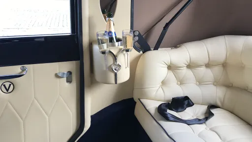 Champagne holder and cream leather interior inside ivory and navy blue Imperial Landaulette wedding car.