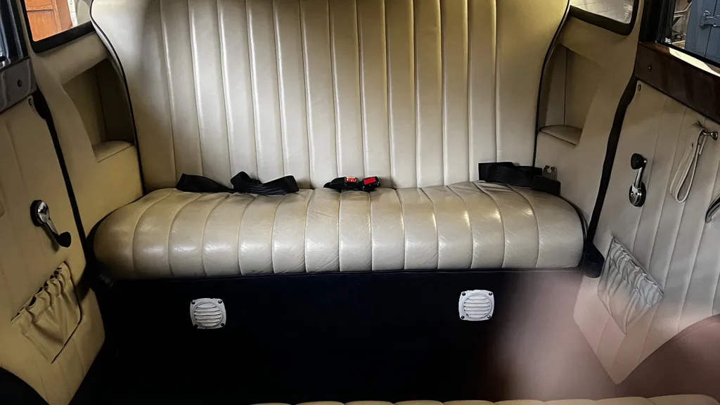 Cream leather rear bench seat inside navy blue and ivory Bramwith limousine.