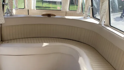 Cream leather L shaped rear seating inside classic Volkswagen Split Screen campervan.