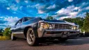 Front three quarter view of black 1967 Chevrolet Impala Fastback with chrome grille and period styling.