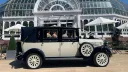 Side view of ivory and navy blue Imperial Landaulette parked outside Palm House Conservatory in Liverpool.