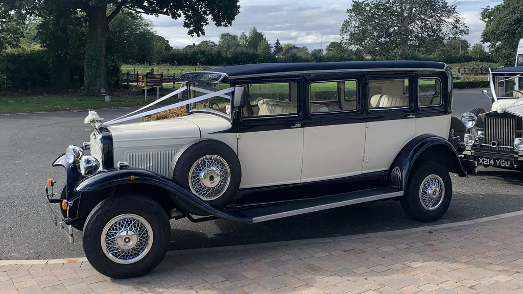 Full left side view of navy blue and ivory Bramwith 7 seater limousine with side mounted spare wheel.