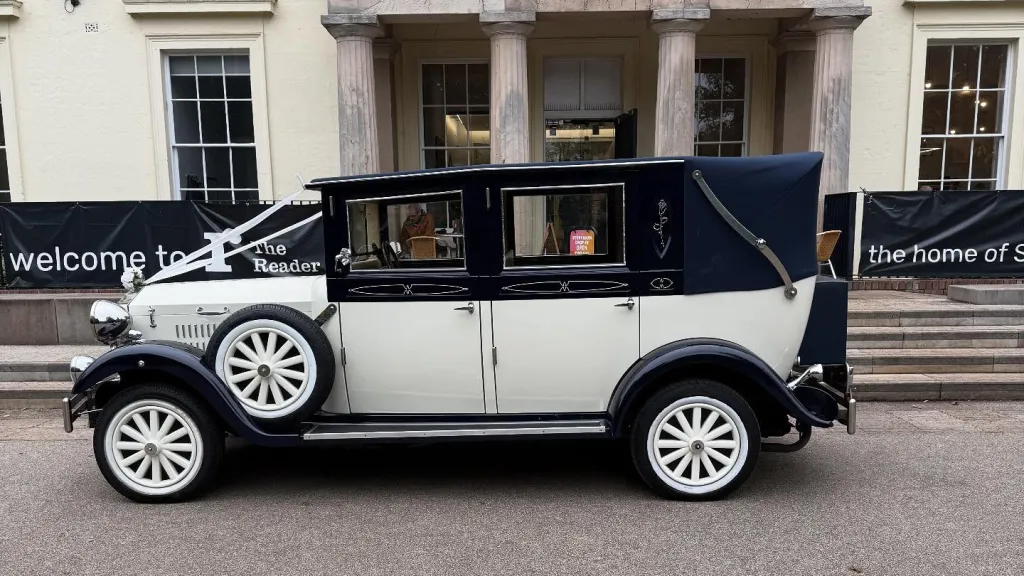 Left side view of ivory and navy blue Imperial Landaulette with navy blue landaulette roof raised.