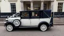 Left side view of ivory and navy blue Imperial Landaulette with navy blue landaulette roof raised.
