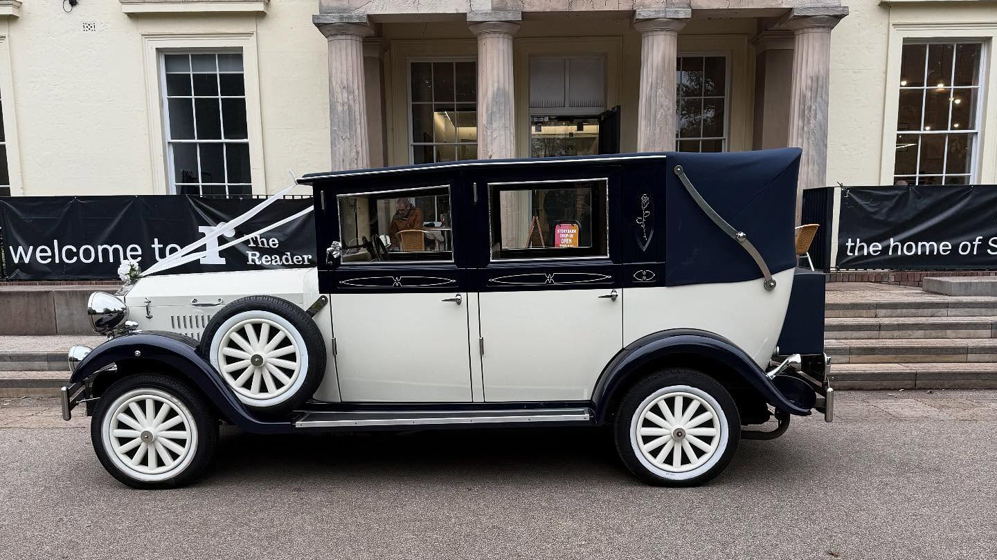 Left side view of ivory and navy blue Imperial Landaulette with navy blue landaulette roof raised.