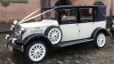 Ivory and navy blue Imperial Landaulette decorated with white wedding ribbons and chrome detailing.