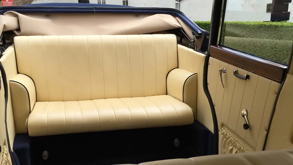Cream leather rear seating inside navy blue and ivory Bramwith Landaulette showing spacious vintage interior.