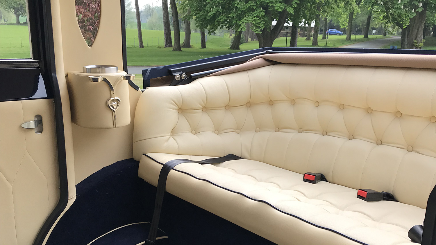 Forward facing cream leather rear seating inside Imperial Landaulette wedding car.