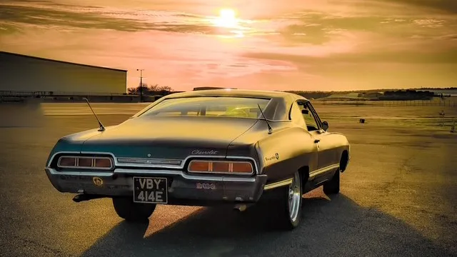 Rear view of black 1967 Chevrolet Impala Fastback photographed at sunset.