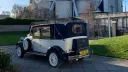 Rear three quarter view of ivory and navy blue Imperial Landaulette with navy blue landaulette roof closed.