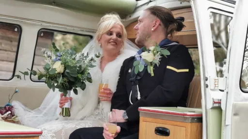 Bride and groom seated inside cream and green Volkswagen Split Screen campervan with vintage interior.