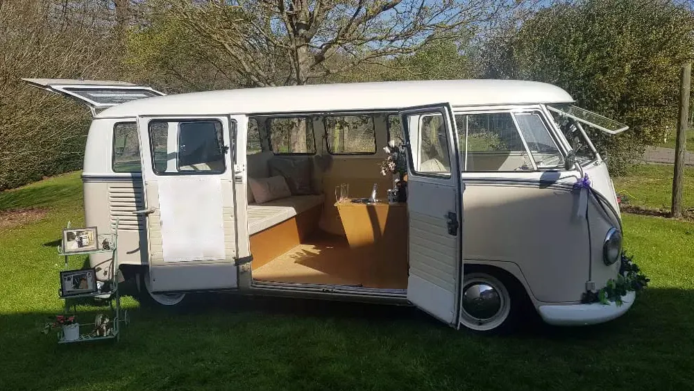 Right side view of cream and beige 1964 VW Split Screen Campervan with side doors open showing the rear passenger cabin.