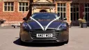 Front view of metallic silver Aston Martin Rapide S decorated with traditional white wedding ribbons.