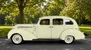 Left side view of cream 1937 Hudson Terraplane showing its curved 1930s bodywork and whitewall tyres.